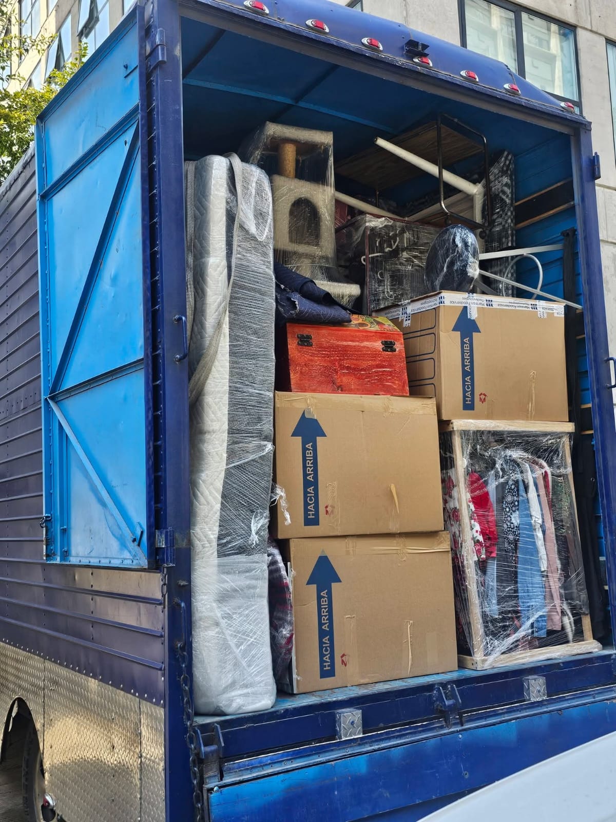 Camión azul con mobiliario acomodado para una mudanza
