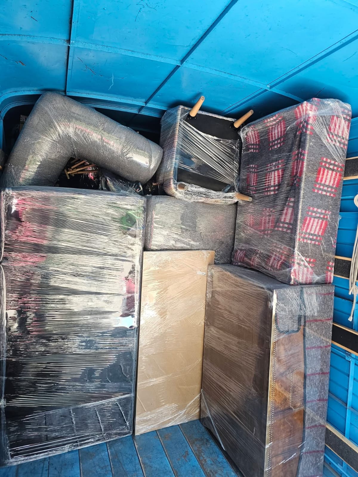 Camión azul con mobiliario protegido y acomodado